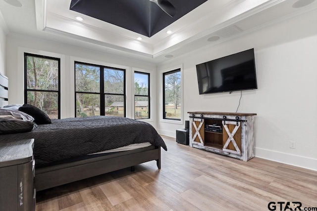 bedroom featuring hardwood / wood-style floors, a tray ceiling, and crown molding