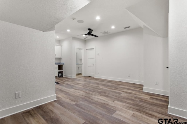 unfurnished living room featuring hardwood / wood-style flooring and ceiling fan