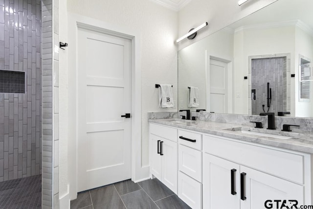 bathroom with tile patterned flooring, vanity, ornamental molding, and tiled shower