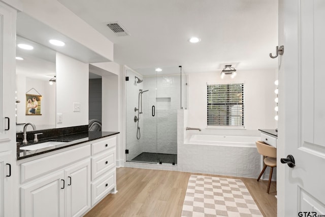 bathroom featuring hardwood / wood-style floors, vanity, and shower with separate bathtub