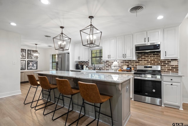 kitchen featuring appliances with stainless steel finishes, a center island, and white cabinetry