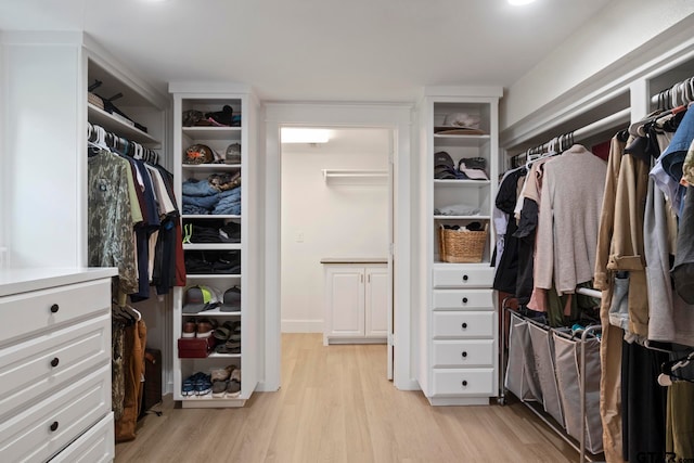 walk in closet with light hardwood / wood-style floors