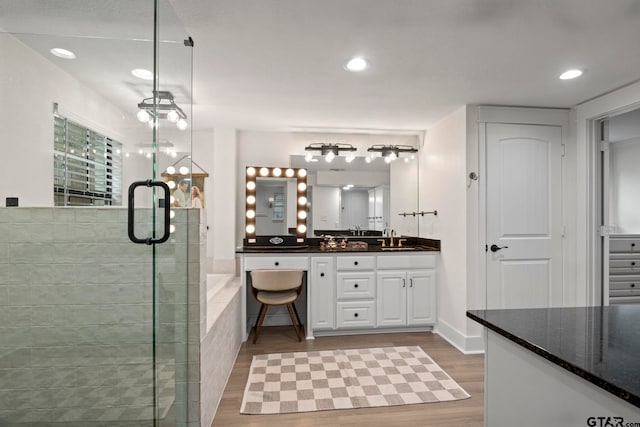 bathroom with hardwood / wood-style floors, vanity, and a shower with door