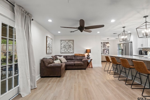 living room with ceiling fan and light hardwood / wood-style floors