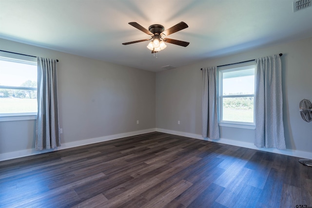 spare room with a wealth of natural light, dark hardwood / wood-style floors, and ceiling fan