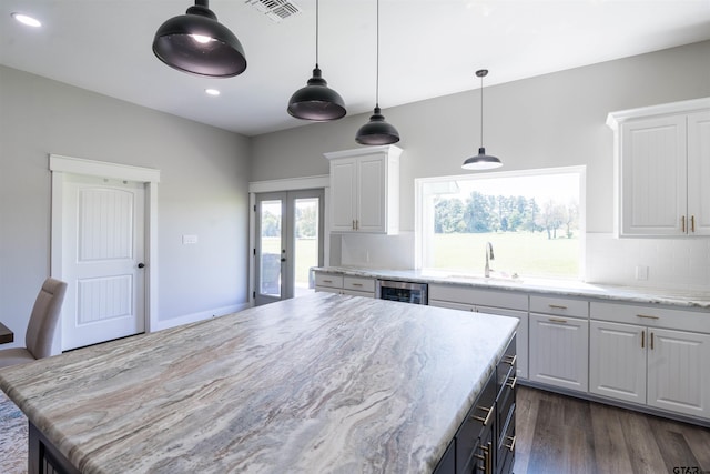 kitchen with white cabinetry, wine cooler, dark hardwood / wood-style floors, a kitchen island, and french doors