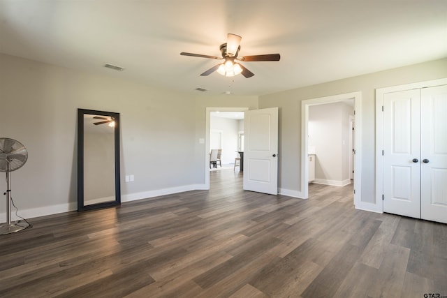 unfurnished bedroom featuring dark wood-type flooring, ceiling fan, and ensuite bath