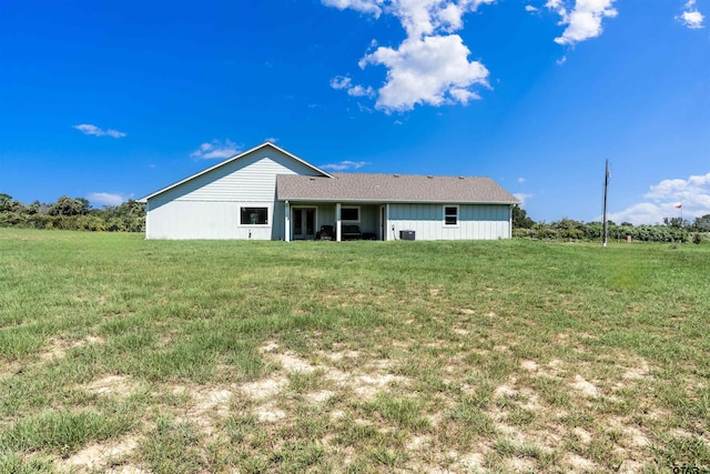 rear view of house featuring a lawn