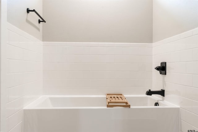 bathroom featuring a bathtub and tile walls