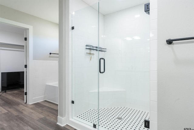 bathroom with hardwood / wood-style flooring and an enclosed shower