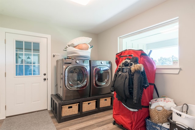 laundry area with washer and clothes dryer and light wood-type flooring