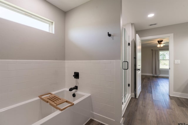 bathroom with plus walk in shower, hardwood / wood-style floors, and ceiling fan