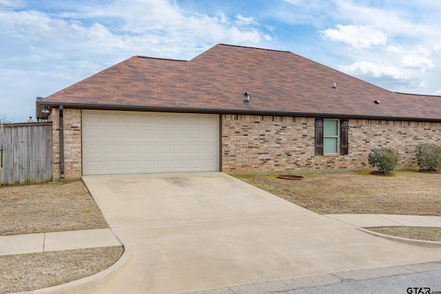 view of front facade featuring fence, roof with shingles, concrete driveway, a garage, and brick siding