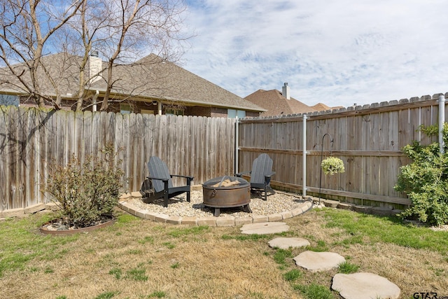 view of yard with a fire pit and a fenced backyard