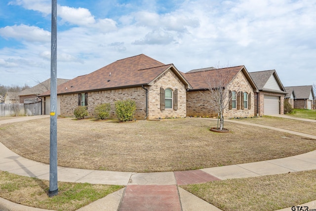 view of front facade with concrete driveway, an attached garage, brick siding, and a front lawn