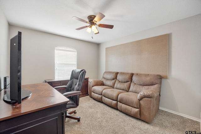 office area with light carpet, baseboards, and a ceiling fan