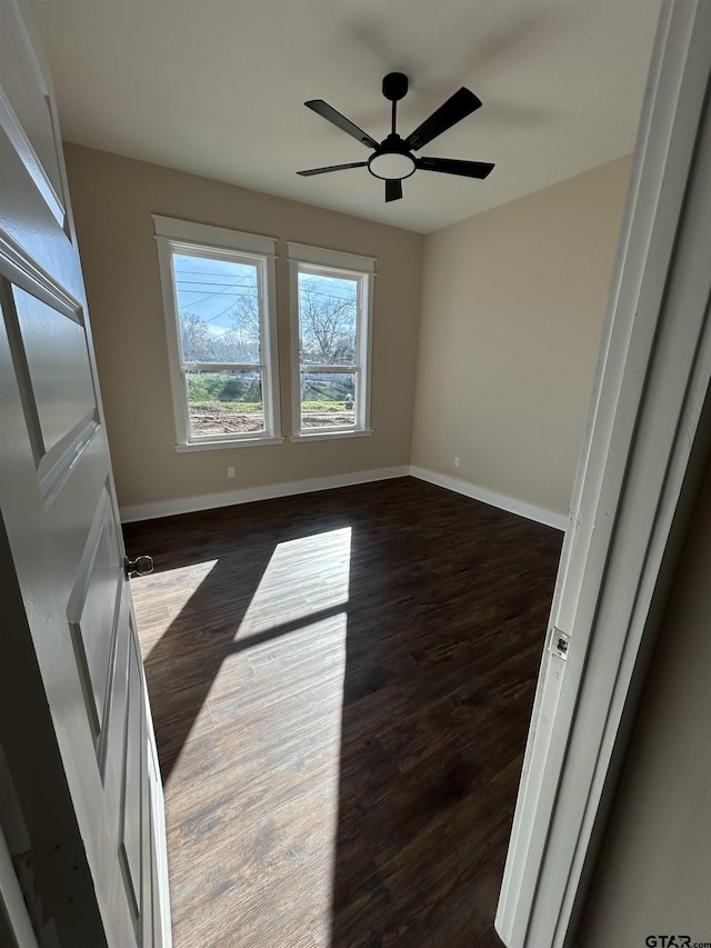 spare room with ceiling fan and dark hardwood / wood-style flooring