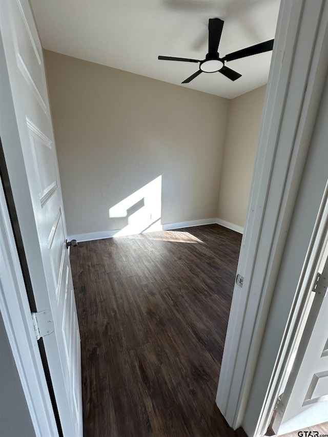 empty room with ceiling fan and dark wood-type flooring