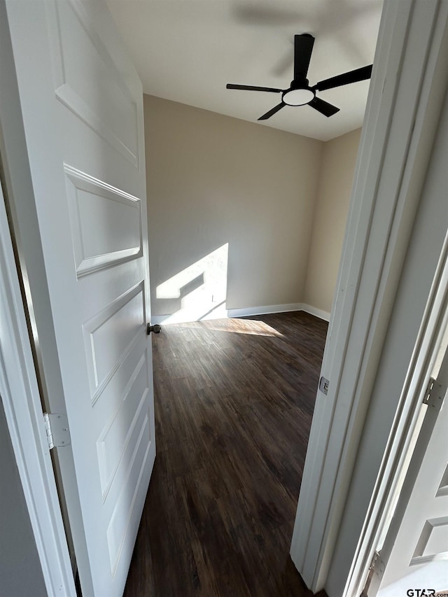 empty room with dark hardwood / wood-style floors and ceiling fan