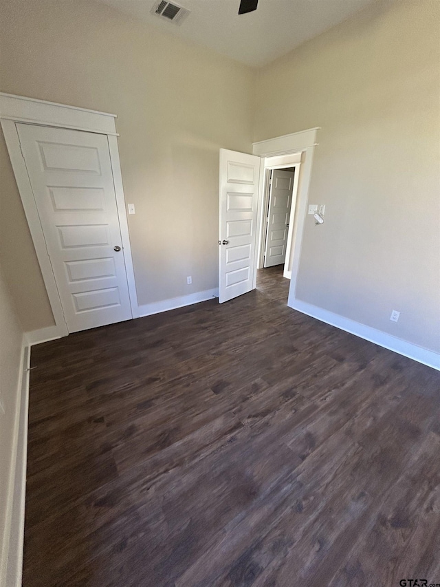 unfurnished bedroom with dark hardwood / wood-style floors and a closet