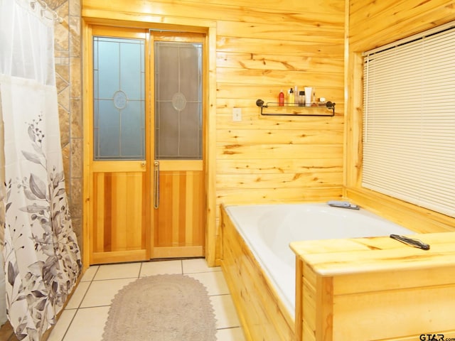 full bath featuring tile patterned floors, wooden walls, and a garden tub