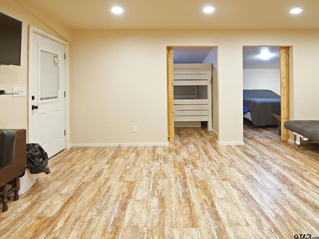 interior space featuring recessed lighting, baseboards, and wood finished floors