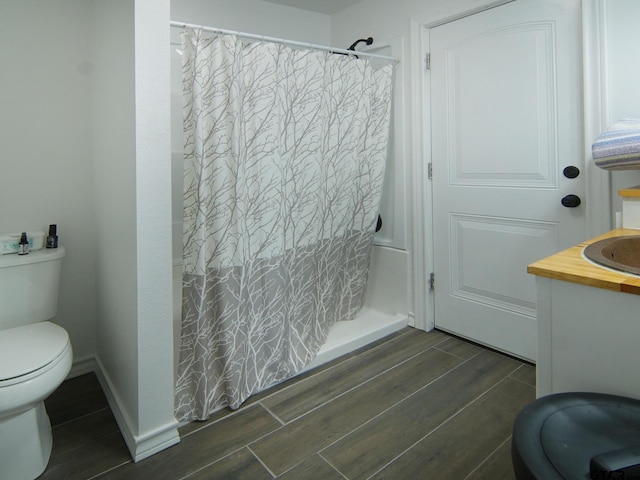 full bathroom with baseboards, wood finish floors, toilet, a shower with shower curtain, and vanity