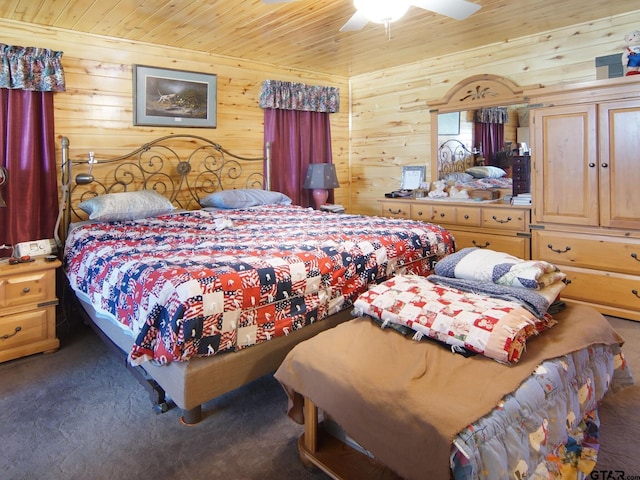 carpeted bedroom with wooden walls, wood ceiling, and a ceiling fan