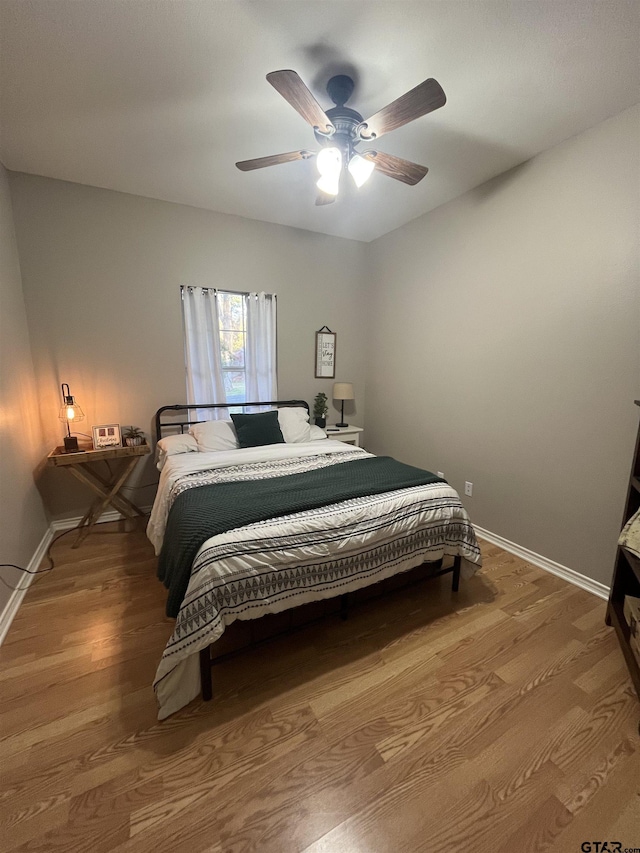 bedroom with hardwood / wood-style floors and ceiling fan