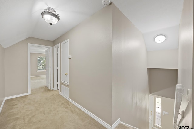 hall with light colored carpet and vaulted ceiling