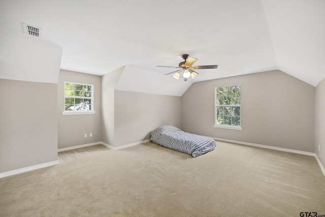 unfurnished bedroom with ceiling fan, lofted ceiling, and light carpet