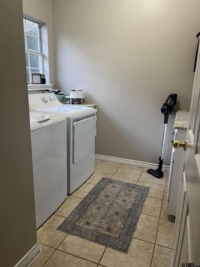 clothes washing area featuring washer and clothes dryer and light tile patterned floors