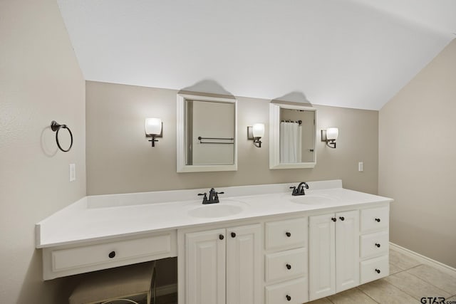 bathroom with tile patterned flooring, vanity, and vaulted ceiling