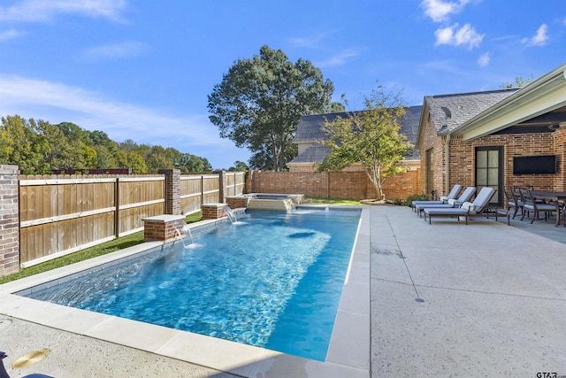 view of swimming pool featuring a patio area, pool water feature, and an in ground hot tub