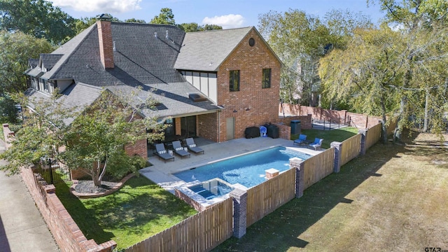 view of swimming pool featuring a yard, a patio area, and an in ground hot tub