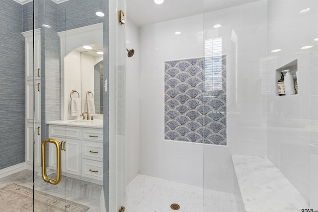 bathroom with a shower with door and vanity