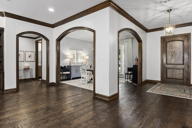 foyer featuring a notable chandelier, ornamental molding, and dark hardwood / wood-style floors