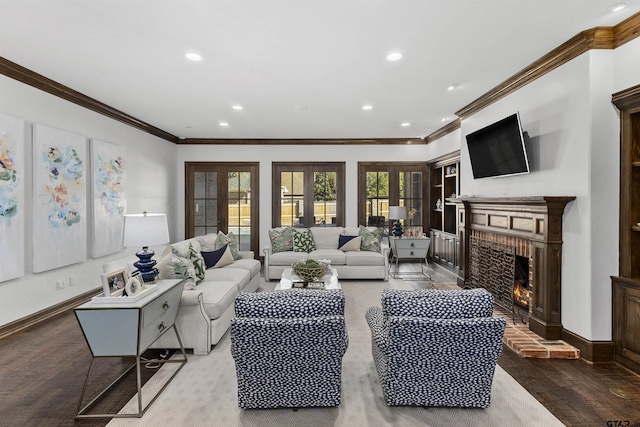 living room with a brick fireplace, hardwood / wood-style flooring, ornamental molding, and french doors