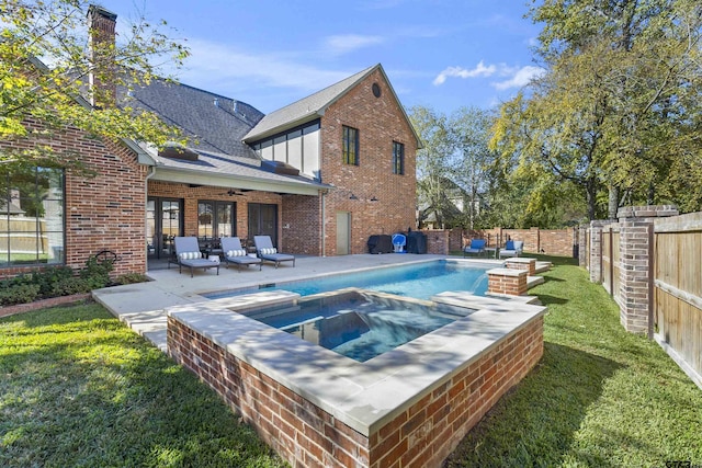 view of pool with a lawn, ceiling fan, outdoor lounge area, a patio, and an in ground hot tub