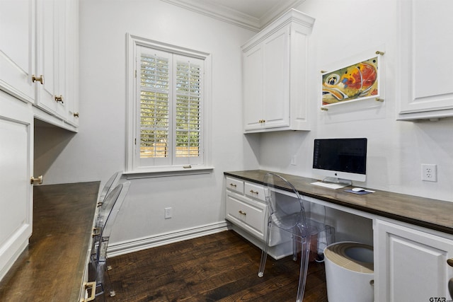 office area with ornamental molding, built in desk, and dark hardwood / wood-style flooring