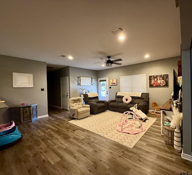 living room featuring ceiling fan and dark hardwood / wood-style flooring