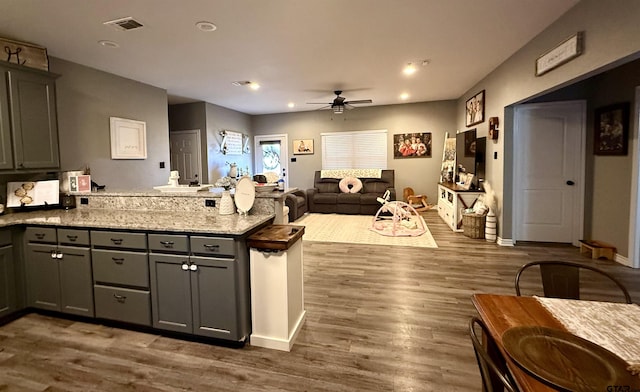 kitchen with dark hardwood / wood-style flooring, gray cabinets, kitchen peninsula, and ceiling fan