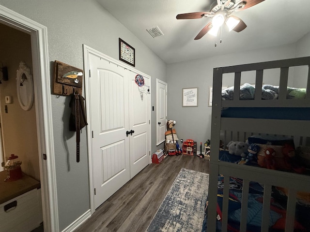 bedroom featuring dark wood-type flooring, a closet, and ceiling fan