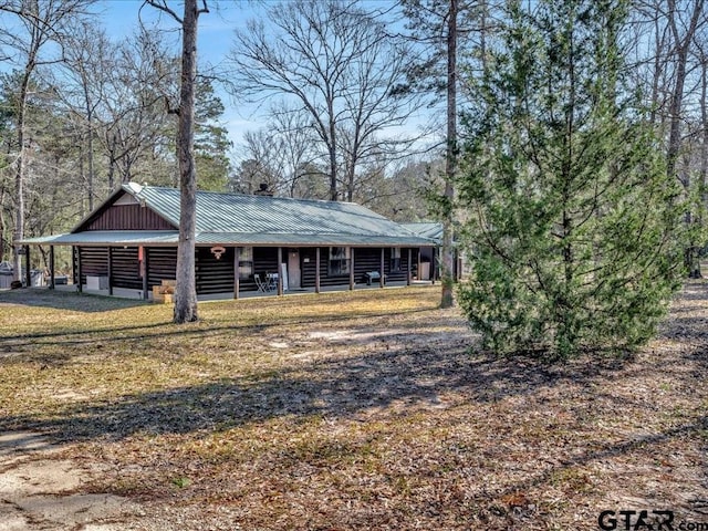 view of front of home with metal roof and log exterior