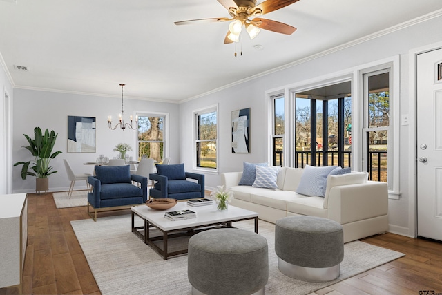 living room with hardwood / wood-style flooring, crown molding, and ceiling fan with notable chandelier