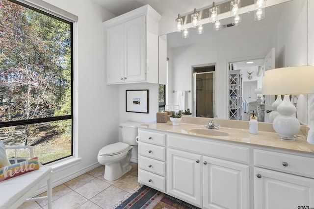 bathroom with toilet, vanity, tile patterned floors, and an enclosed shower