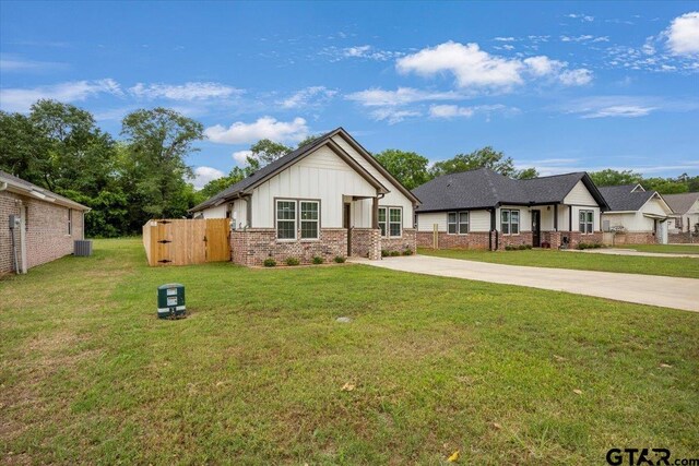 509 Zimmerman Dr, Jacksonville, TX 75766 - modern farmhouse featuring board and batten siding, fence, concrete driveway, and a front yard