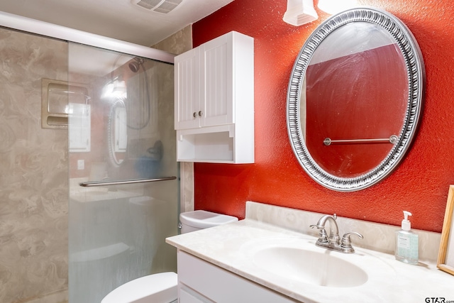 bathroom with toilet, vanity, and walk in shower