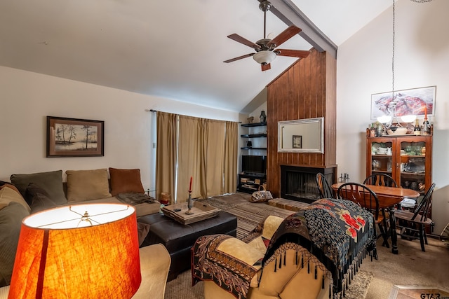 carpeted living room with ceiling fan, wood walls, a fireplace, and high vaulted ceiling