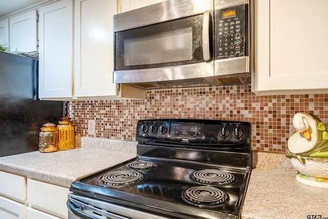 kitchen featuring white cabinetry and black range with electric stovetop